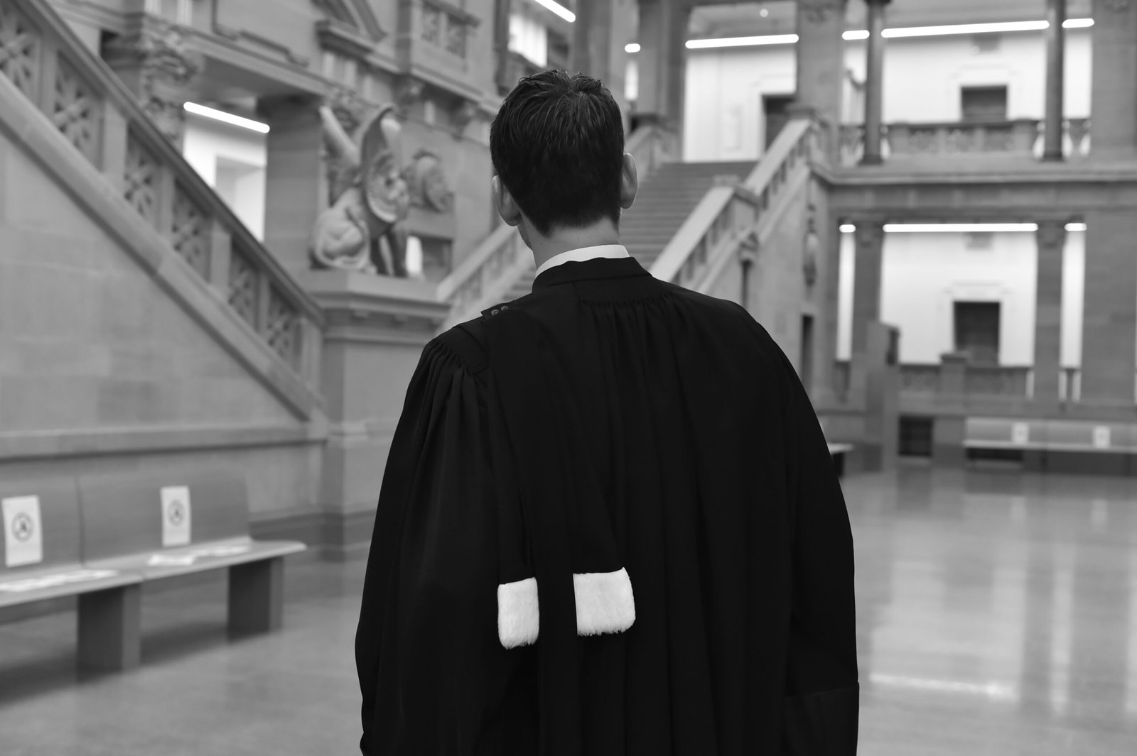 Avocat en robe noire de dos dans un palais de justice à Strasbourg