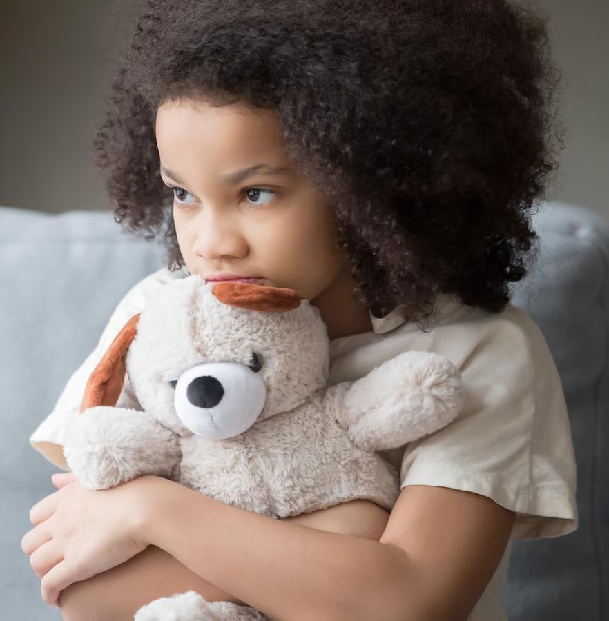 Enfant inquiet tenant un ours en peluche, illustrant les conséquences psychologiques d’une procédure pénale
